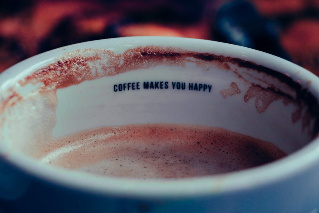 focus photo of white ceramic cup filled with coffee