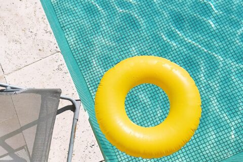 yellow pool float on swimming pool edge