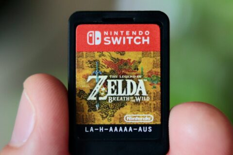 a hand holding a nintendo wii game card