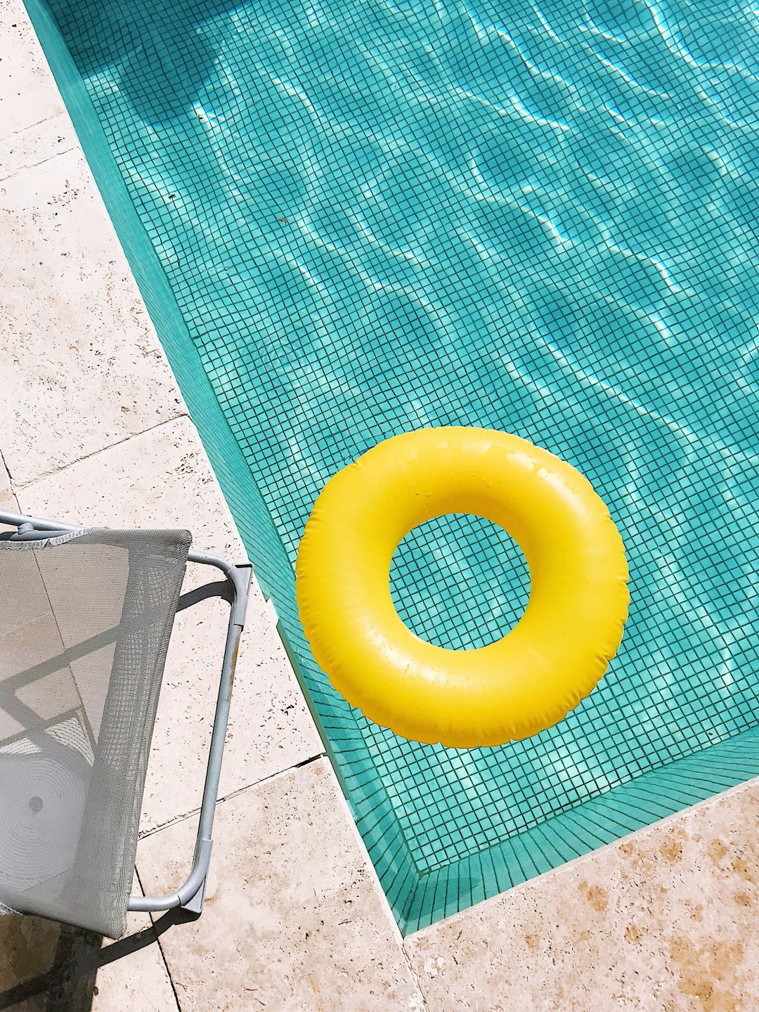 yellow pool float on swimming pool edge