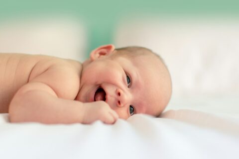 baby lying on fabric cloth