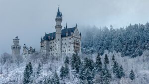 Neuschwanstein Castle on a snowy hillside surrounded by frost-covered pine trees in Germany