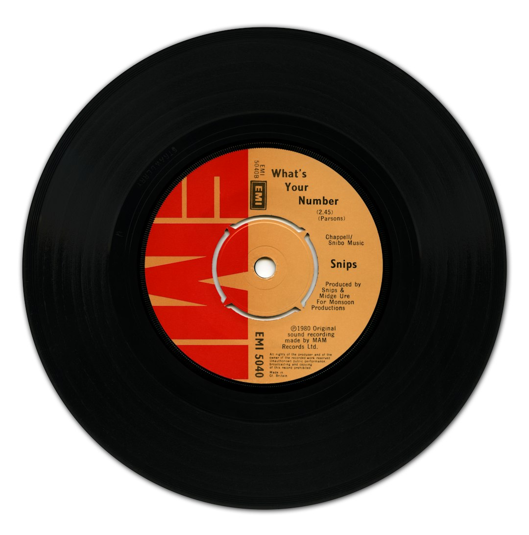 A black vinyl record with a red and orange EMI label