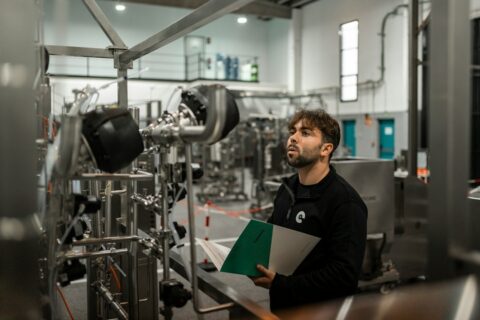 A man inspects machinery in a factory